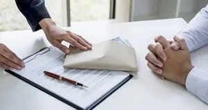 A person is wrapping a package on top of a table. A person is wrapping a package on top of a table.