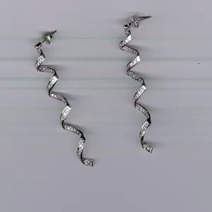 A pair of silver earrings hanging on the wall.